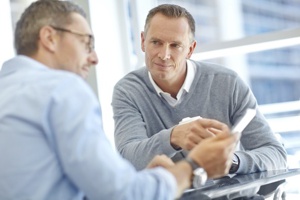 Two mature businessmen using a digital tablet together during a meeting